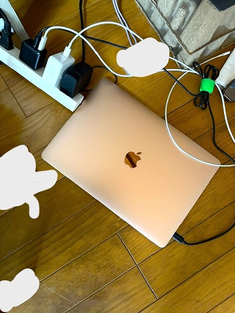 床に直置きでMacBook Airを充電している写真